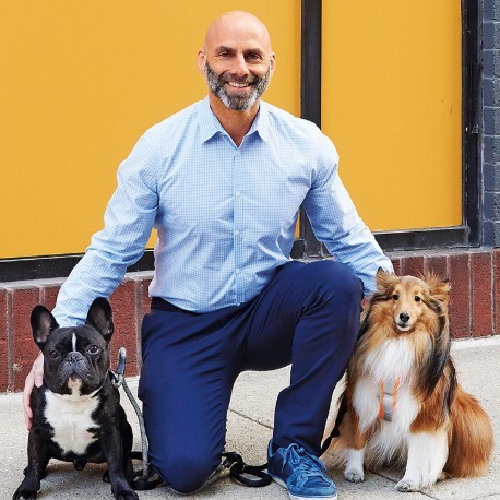 Dan Rubenstein CEO of PUPS Pet Club daycare services with two dogs